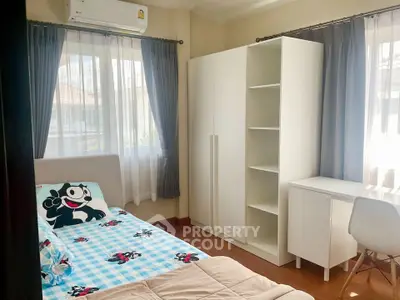 Bright and cozy bedroom with modern furniture and ample natural light.