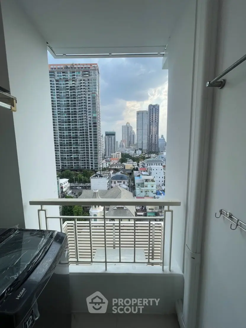 Stunning city view from a high-rise balcony with modern washing machine setup.