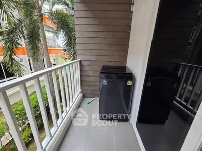 Charming balcony with washing machine and lush garden view, perfect for urban living convenience.