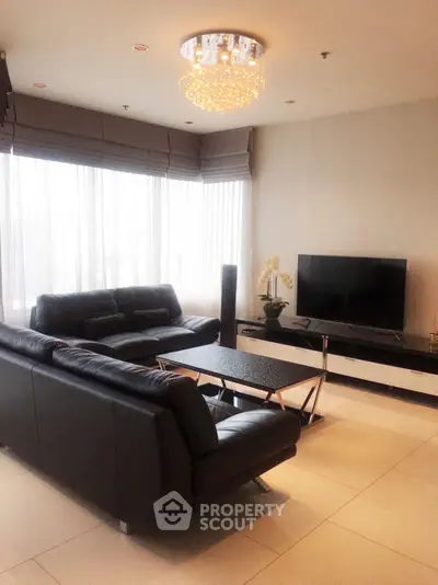 Luxurious living room with modern black leather sofas and elegant chandelier