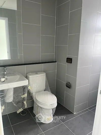 Modern bathroom with sleek gray tiles and new fixtures