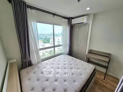 Bright bedroom with large window and city view, featuring a comfortable bed and air conditioning.
