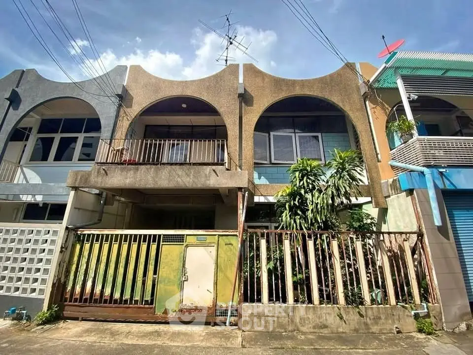 Charming townhouse exterior with unique architectural design and lush greenery, perfect for urban living.