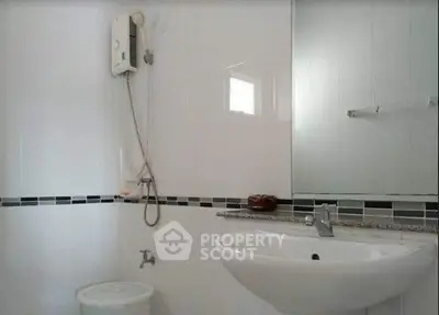 Modern bathroom with sleek white tiles and stylish fixtures.