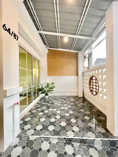 Stylish covered patio with modern tile flooring and decorative wall accents.