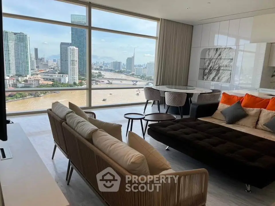Luxurious living room with stunning river view and modern furnishings in high-rise apartment.