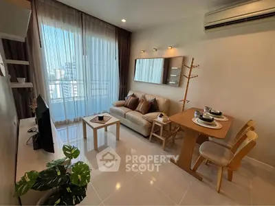 Modern living room with cozy seating and dining area, featuring large windows and stylish decor.
