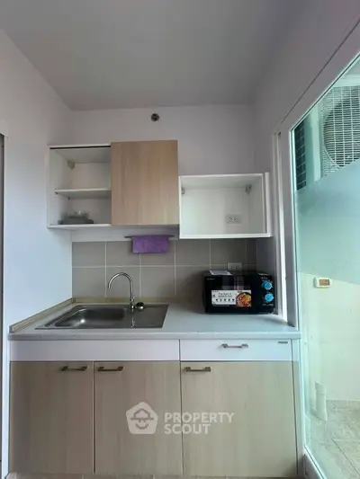 Compact modern kitchen with sleek cabinetry and built-in appliances