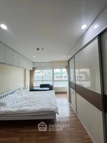 Spacious bedroom with large windows and modern furnishings