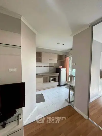 Modern compact kitchen with open layout and sleek appliances in a cozy apartment setting.