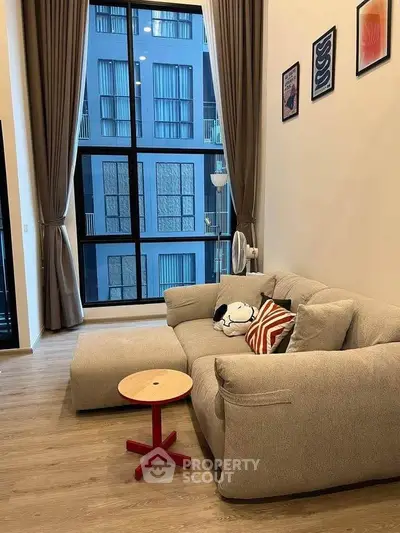 Modern living room with large window and stylish decor in urban apartment