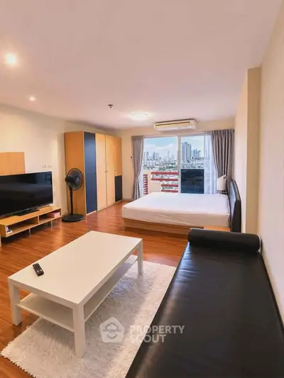 Spacious studio apartment with modern furnishings and city view, featuring a cozy living area and large windows.