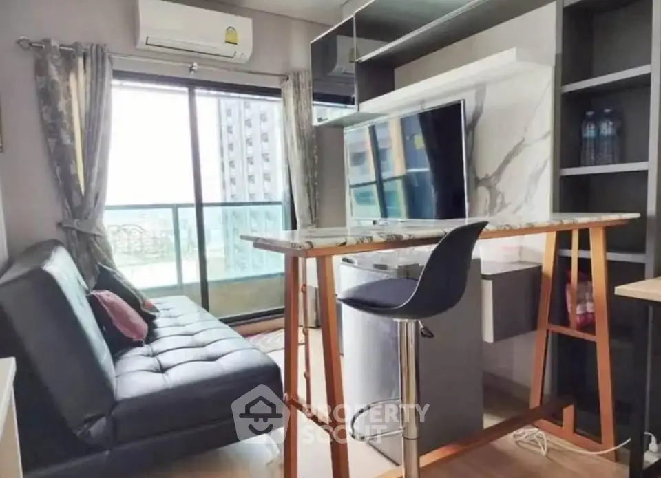 Modern living room with balcony view, featuring sleek furniture and stylish decor in a high-rise apartment.