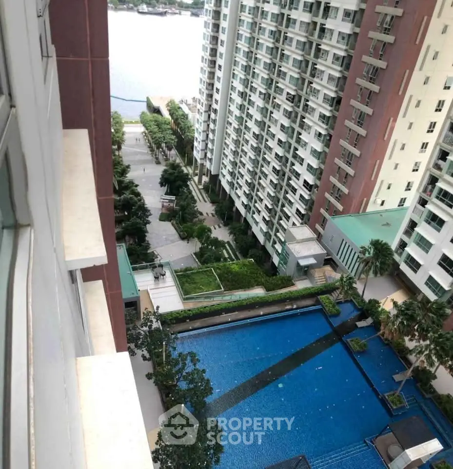 Stunning high-rise apartment view with pool and lush greenery, perfect for urban living.
