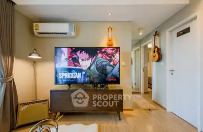 Modern living room with stylish decor, featuring a large TV and musical instruments, perfect for entertainment.
