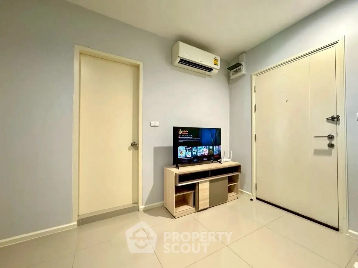 Modern living room with sleek TV setup and air conditioning in a cozy apartment.