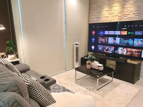 Modern living room with cozy seating and large flat-screen TV, perfect for entertainment.