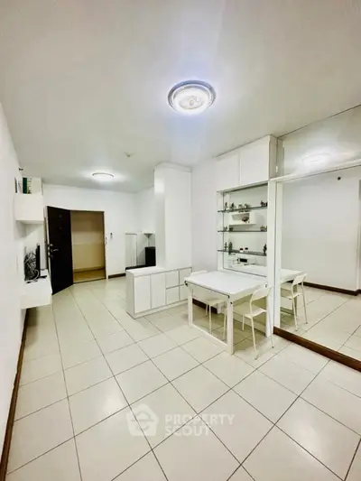 Spacious modern living room with sleek white furniture and elegant tile flooring.
