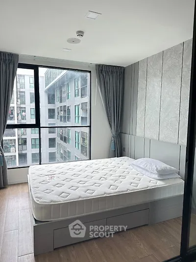 Modern bedroom with large window and stylish decor in urban apartment