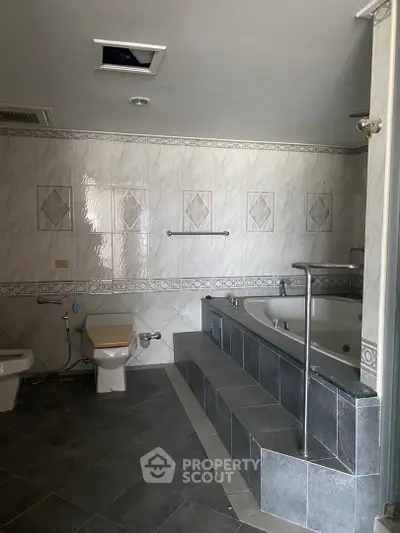 Spacious bathroom with luxurious bathtub and elegant tile design