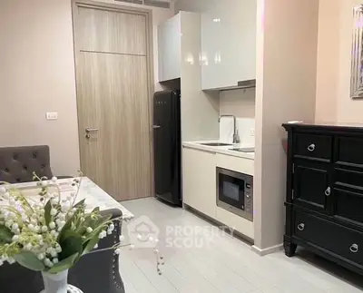 Modern kitchen with sleek cabinetry and built-in appliances in a cozy apartment setting.