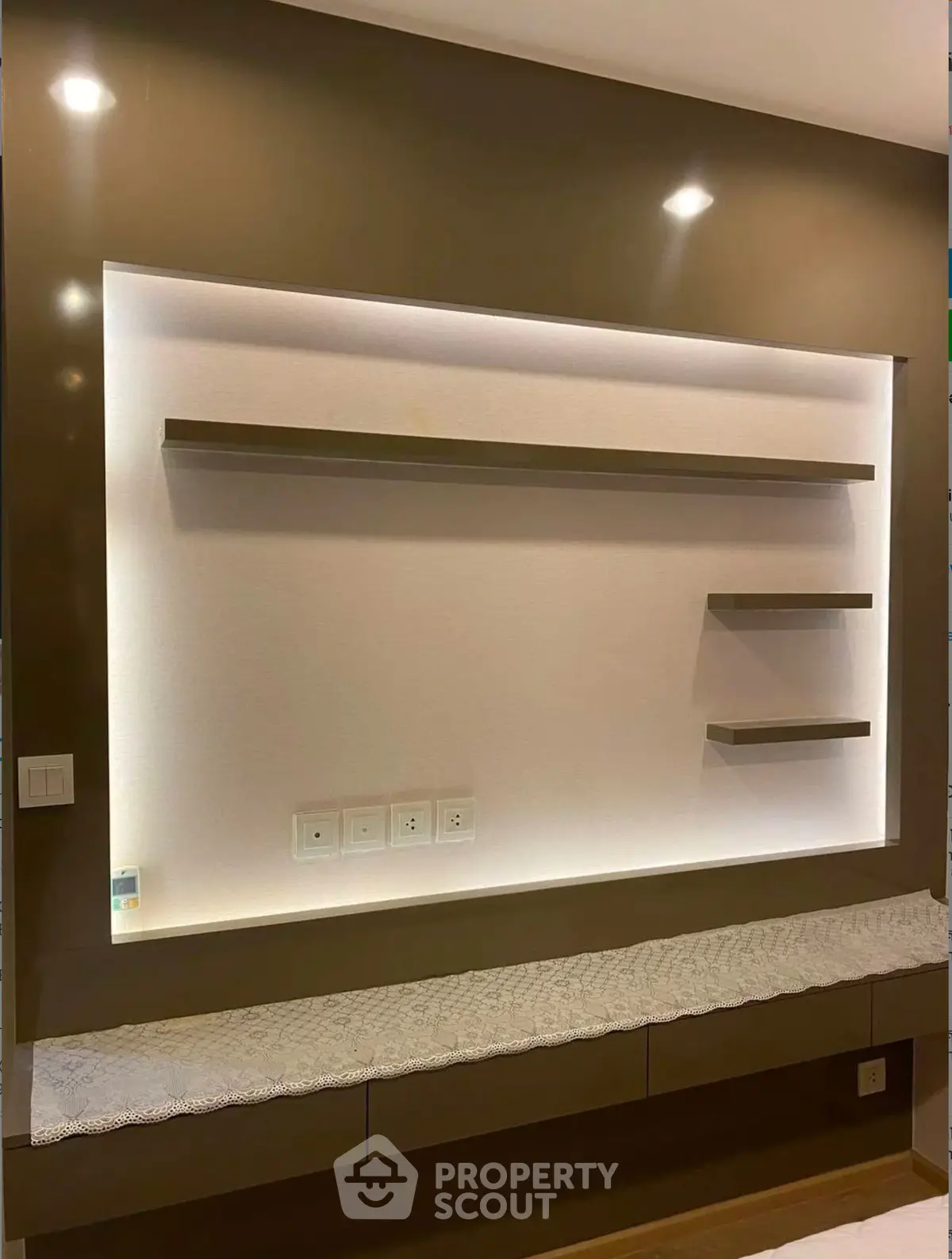 Modern interior wall with built-in shelves and ambient lighting, perfect for stylish living room decor.