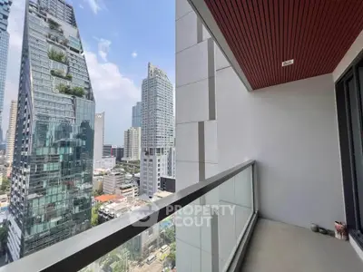 Stunning city view from modern high-rise balcony with sleek glass railing.