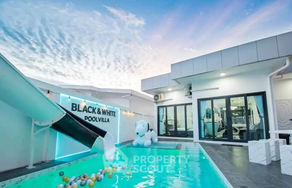 Luxurious pool villa with modern design and playful slide, perfect for family getaways.