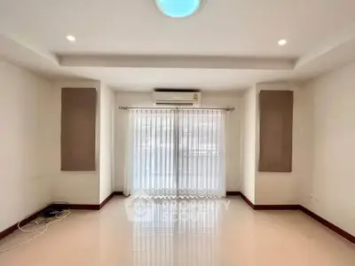 Spacious living room with large windows and modern lighting