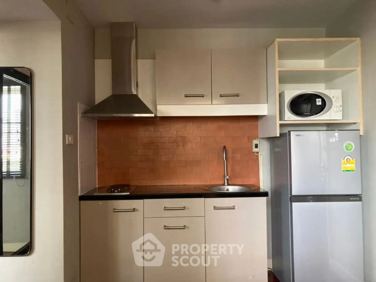 Modern compact kitchen with sleek cabinetry and stainless steel appliances