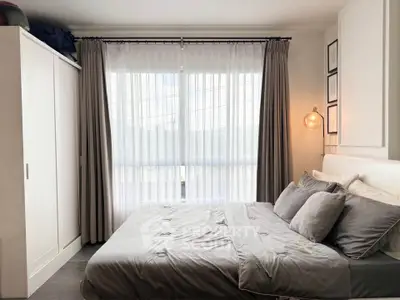 Cozy bedroom with modern decor and large window for natural light