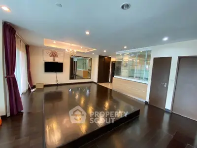 Spacious modern living room with elegant dark wood flooring and stylish lighting
