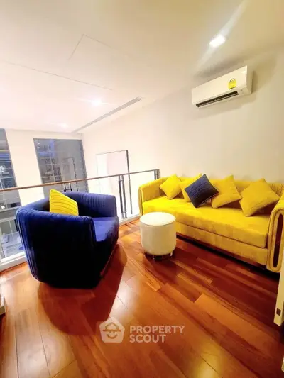 Stylish living room with vibrant yellow and blue sofas, wooden flooring, and modern decor.