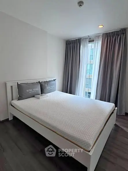 Modern bedroom with large window and stylish curtains in a contemporary apartment.