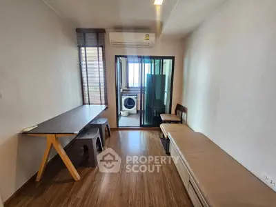 Modern living room with wooden flooring and glass door to laundry area