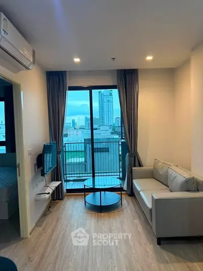 Modern living room with city view, featuring sleek furniture and large windows for natural light.