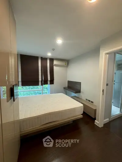 Modern bedroom with large window and air conditioning in a stylish apartment.
