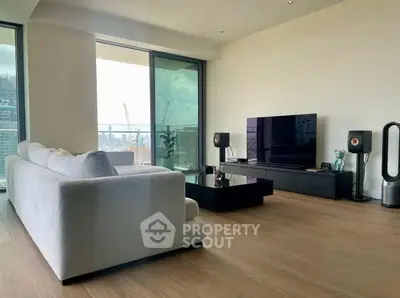 Modern living room with sleek furniture and city view balcony.