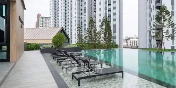 Luxurious rooftop pool with modern lounge chairs and stunning cityscape views.