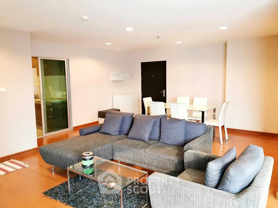Spacious modern living room with stylish furniture and dining area in open layout apartment.