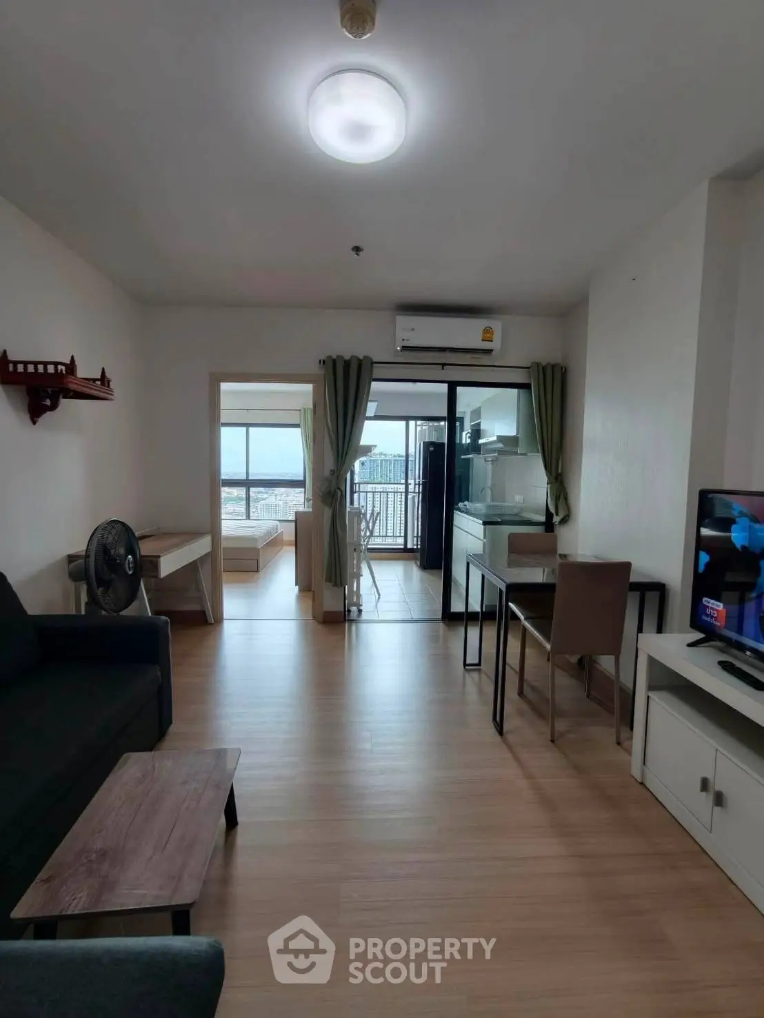 Modern apartment interior with open layout, featuring living room, dining area, and balcony with city view.