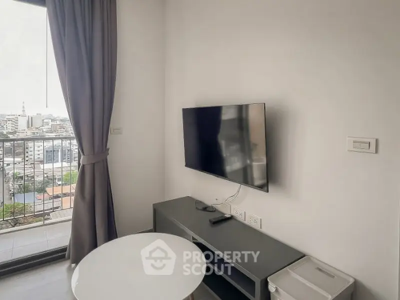 Modern living room with wall-mounted TV and city view balcony