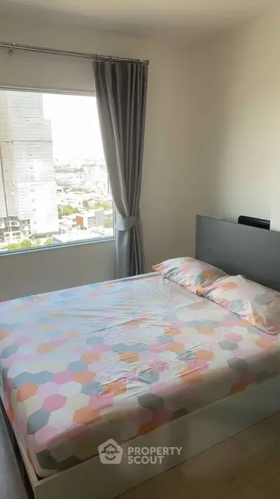 Cozy bedroom with large window offering city view, featuring modern bed and stylish curtains.