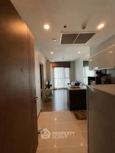 Modern apartment interior with open kitchen and living area, featuring sleek design and natural light.