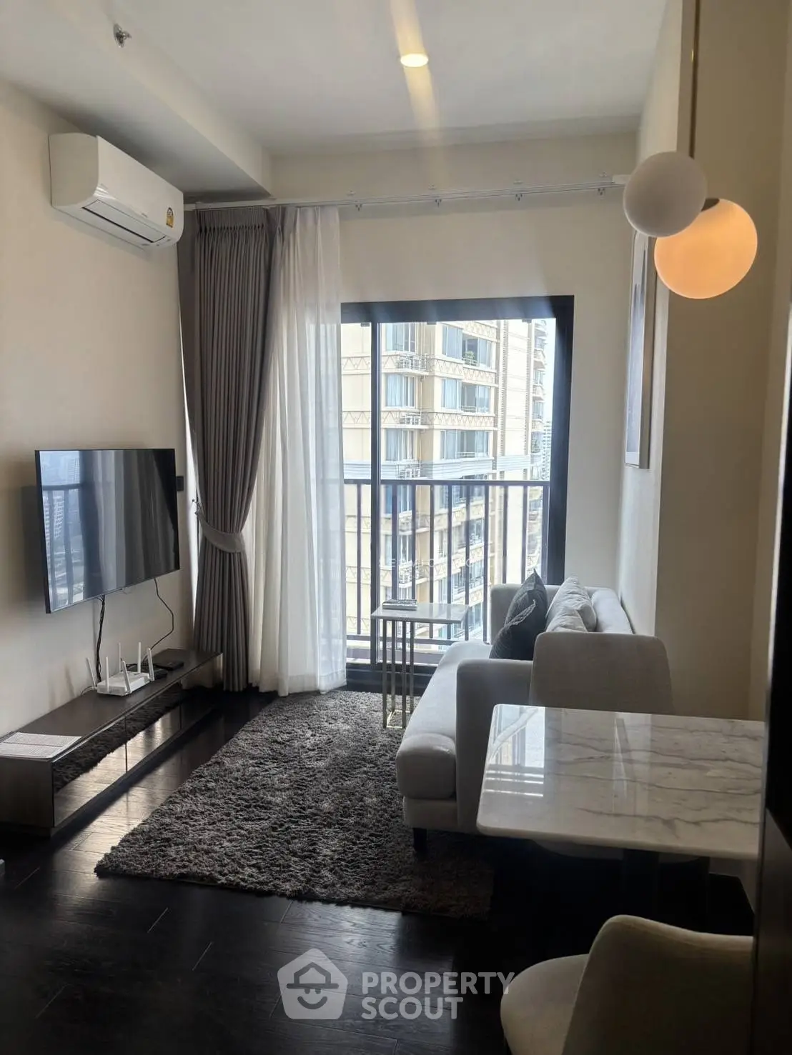 Modern living room with city view, featuring sleek furniture and large windows for natural light.