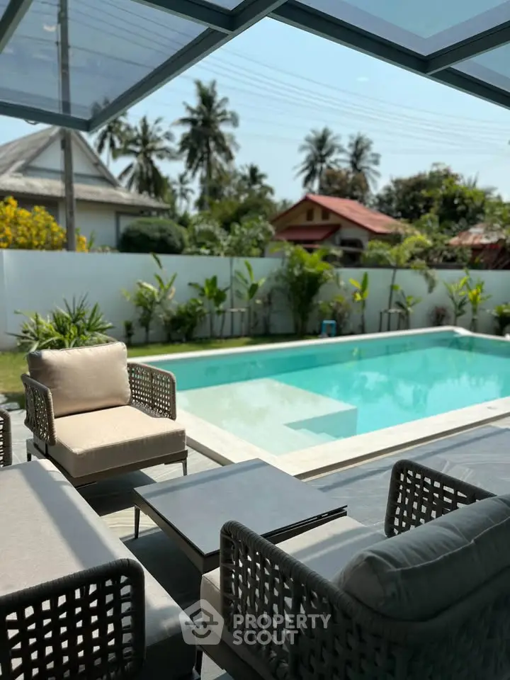 Luxurious outdoor pool area with stylish seating and lush greenery, perfect for relaxation and entertainment.