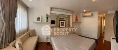 Spacious bedroom with modern decor and cozy seating area, perfect for relaxation.