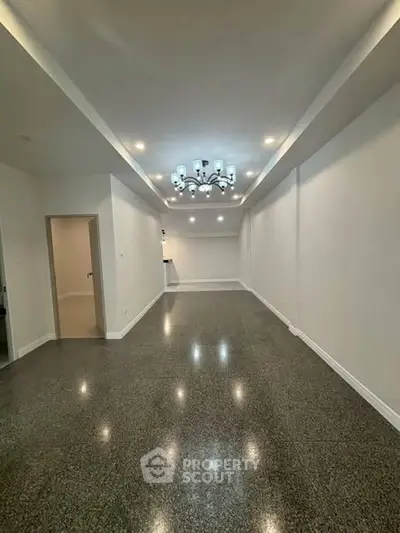 Spacious modern living room with elegant lighting and polished flooring, perfect for stylish urban living.