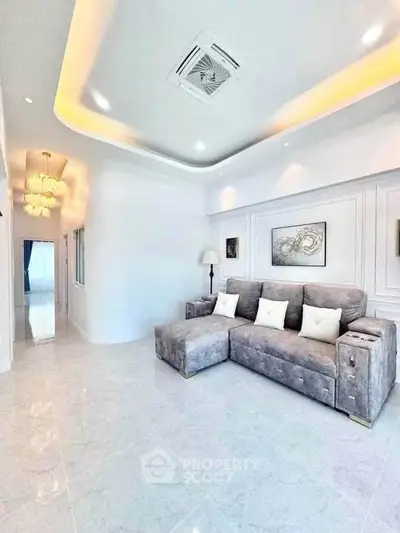 Spacious modern living room with elegant lighting and plush gray sofa