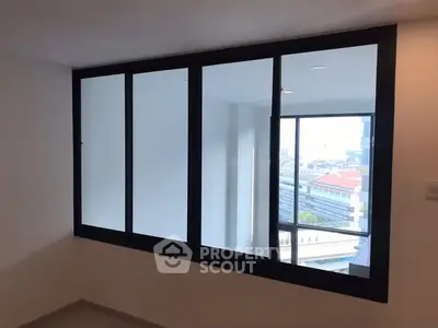 Spacious room with large windows offering city view in modern apartment